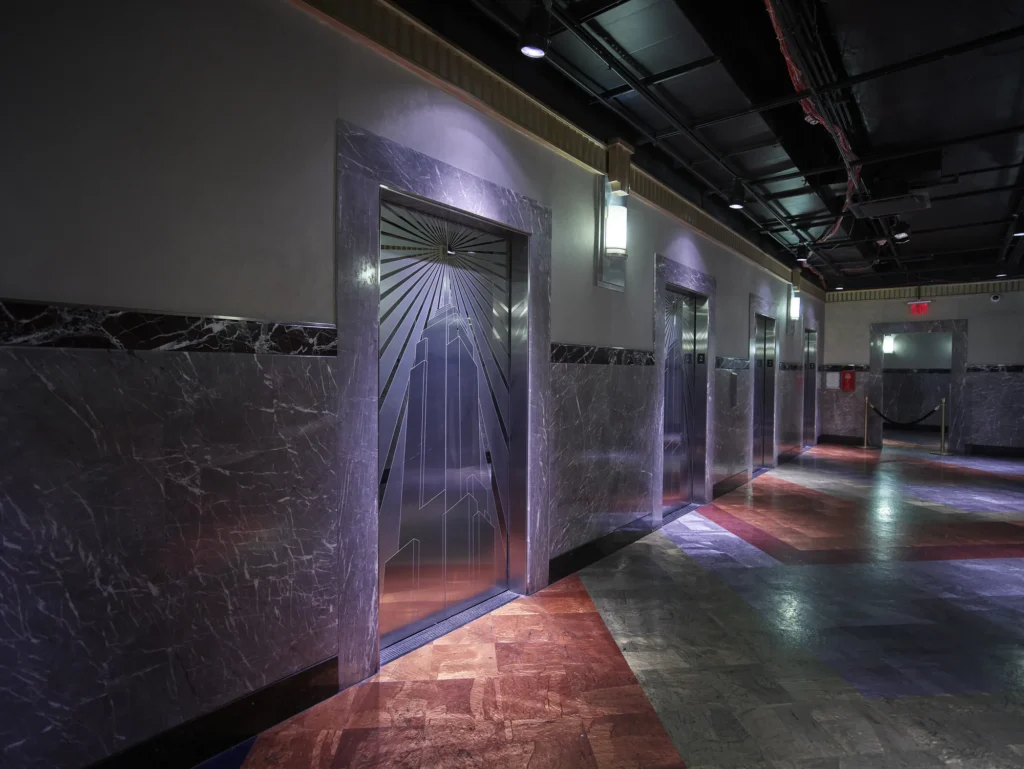 Metal elevator doors with sunburst motifs and marble walls in the Empire State Building lobby