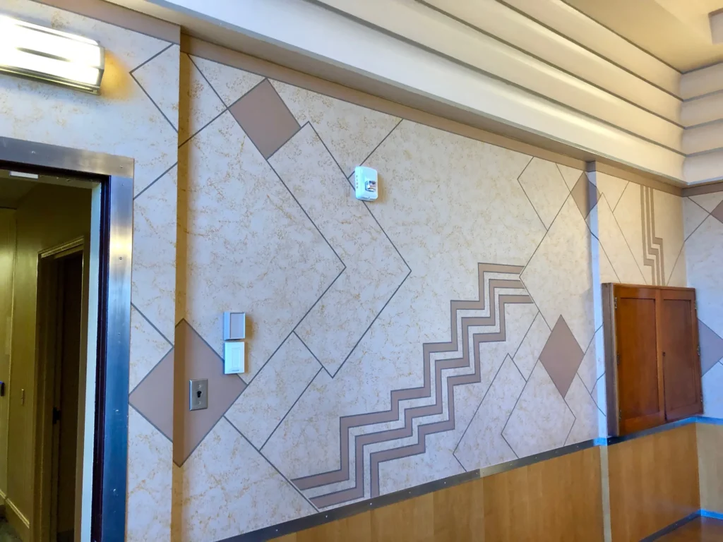 Art Deco wall decorated with zigzag and stepped geometric patterns above wood wainscoting